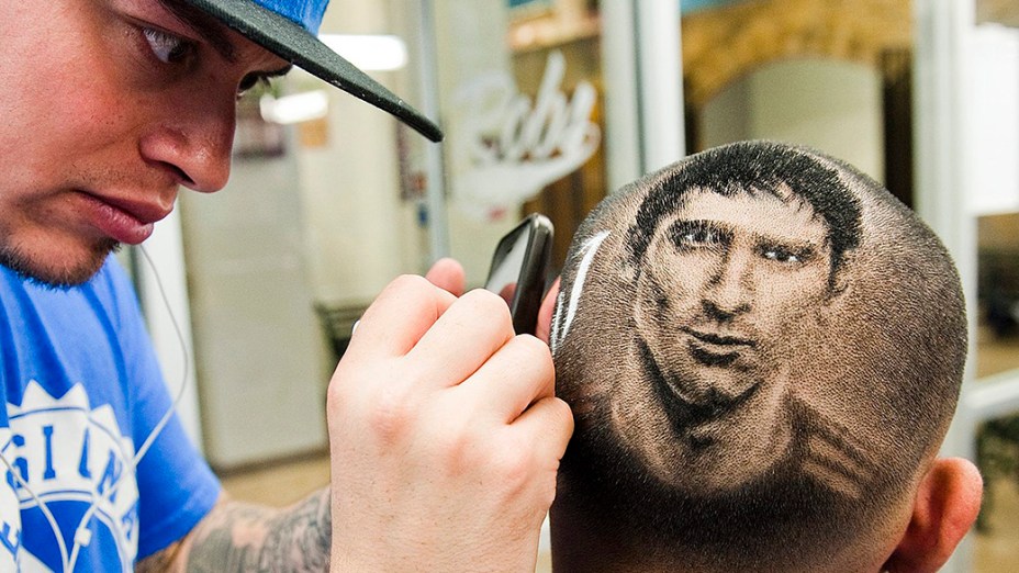 O cabelereiro Rob Ferrel, conhecido como Rob the Original, faz a imagem do craque argentino Lionel Messi na cabeça de um cliente em sua barbearia em San Antonio, no Texas