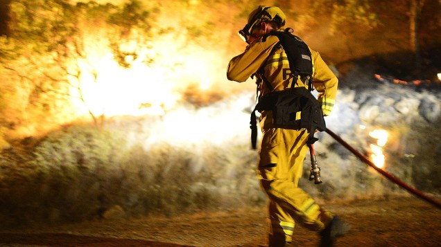 Bombeiro trabalha para extinguir um incêndio florestal em Santa Helena, na Califórnia