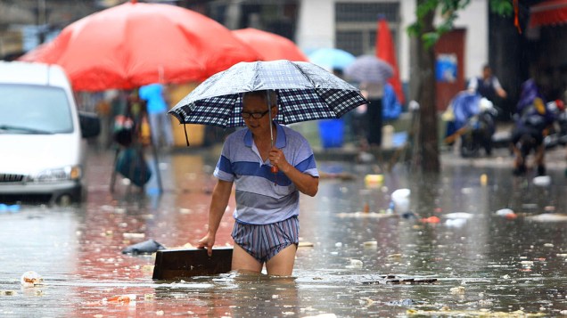 Homem caminha por área inundada, na cidade de Changsha, região central da China. Segundo o departamento de meteorologia, chuvas pesadas deverão atingir todo o país ainda nesta semana 