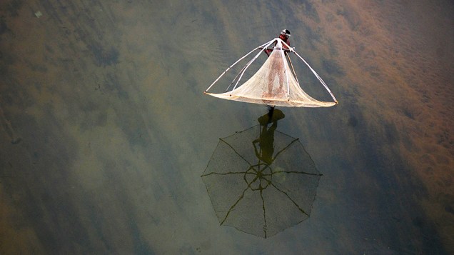 Pescador lança sua rede ao rio Daya perto da aldeia Basantapur, na Índia