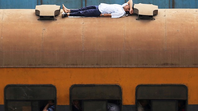 Um homem viaja em cima de um vagão de trem no Cairo