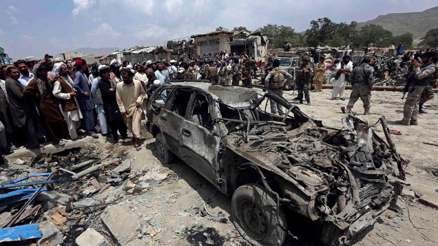 Forças de segurança afegãs e moradores se reúnem no local onde um carro-bomba explodiu, na província de Paktika, matando 90 pessoas; Segundo informaram as autoridades, este foi um dos ataques mais violentos no país em um ano