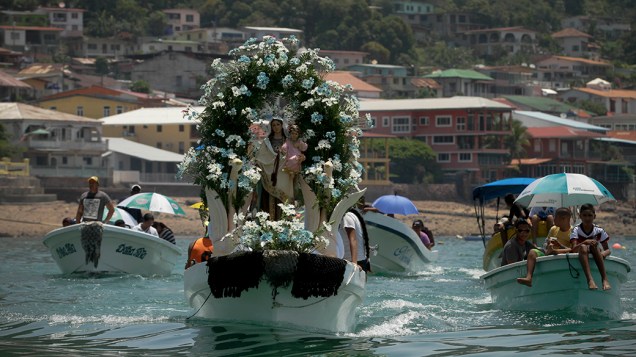 Uma estátua da Nossa Senhora do Carmo é vista em um barco de pesca durante uma procissão em Taboga, no Panamá; Comunidades pesqueiras em todo o país celebraram o dia da Santa, que é adorada pelos católicos como o padroeira dos pescadores e marinheiros