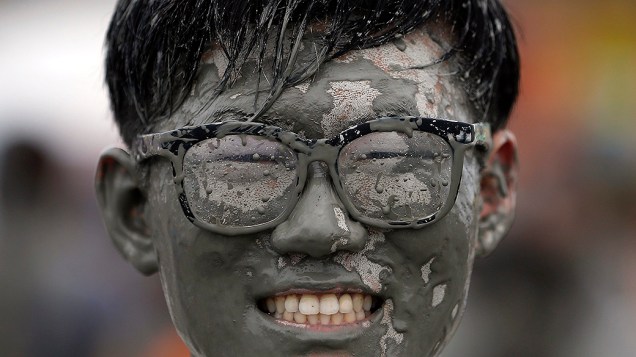 Turista posa para foto durante o festival anual de lama na praia de Daecheon em Boryeong, na Coreia do Sul