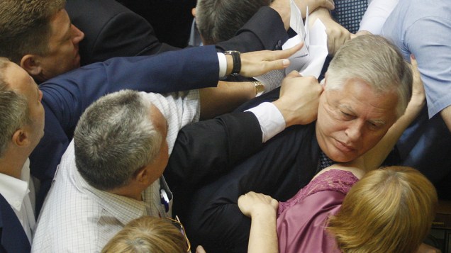 Deputados ucranianos atacam o chefe da facção parlamentar comunista, Petro Symonenko, enquanto tentam tirá-lo do salão durante uma sessão, em Kiev