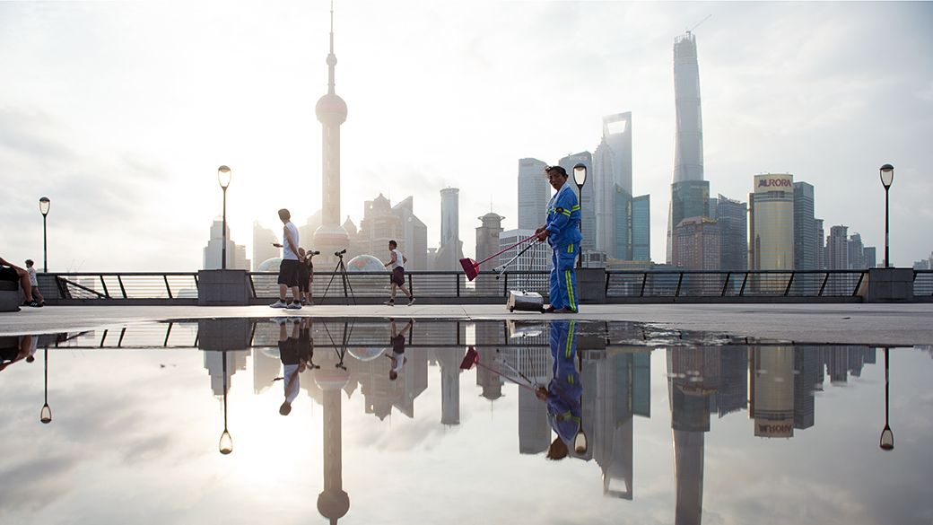 Um trabalhador é visto ao longo do rio Huangpu, no distrito financeiro de Lujiazui, em Xangai. O crescimento chinês acelerou a previsão para 7,5 %, batendo o recorde do segundo trimestre, como informam os dados oficiais