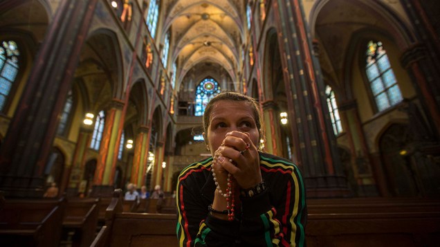 Mulher faz oração em homenagem às vítimas do acidente com o voo MH17 da Malaysia Airlines na Ucrânia, na igreja Onze Lieve Vrouwen em Amsterdã, na Holanda 