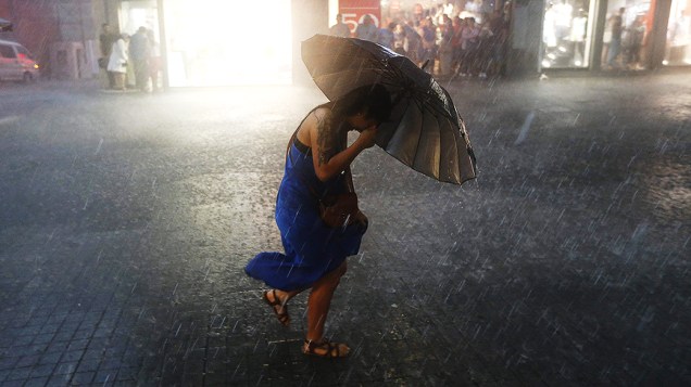 Mulher se protege da chuva durante tempestade em Istambul, na Turquia