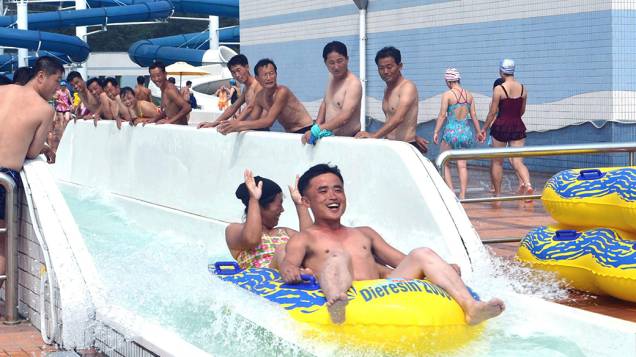 Foto cedida pela Agência Central de Notícias da Coréia do Norte (KNCA), mostra trabalhadores e as crianças se divertindo em uma piscina na capital Pyongyang