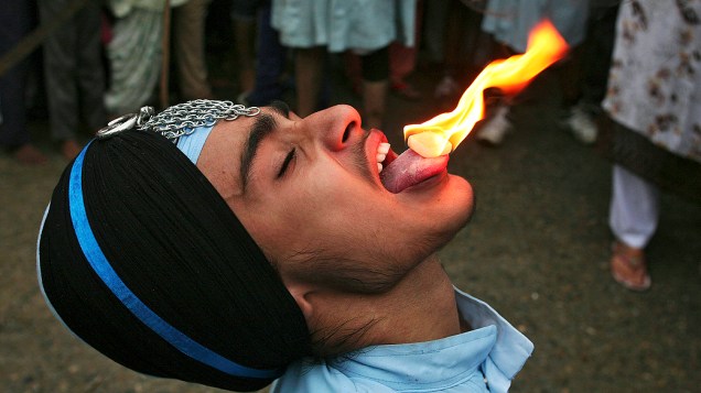 Indiano executa truques com fogo durante as celebrações do 410º aniversário da instalação do Guru Granth Sahib, o livro sagrado e religioso do sikhismo, na cidade de Amritsar