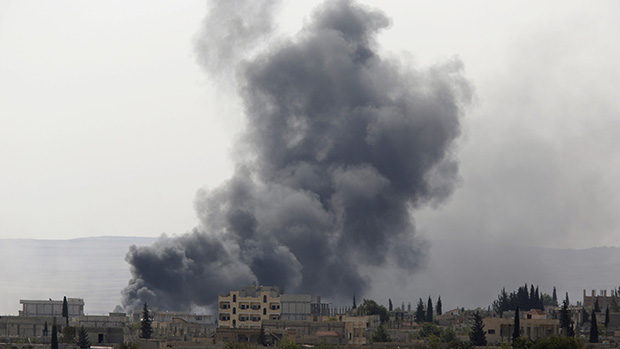 Nuvem de fumaça após aviões da coalizão internacional bombardearem a cidade de Kobani, território sírio perto da fronteira entre a Síria e a Turquia. A aviação internacional atacou zonas onde o grupo Estado Islâmico (EI) se concentrava, no sudeste de Kobani