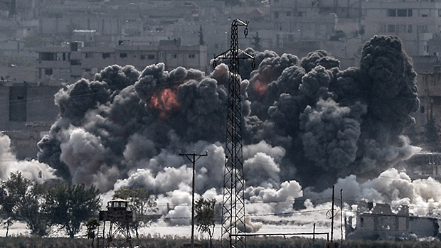 Uma explosão na sequência de um ataque aéreo cobre de fumaça a cidade síria de Kobani na fronteira com a Turquia. Ao todo, 815 pessoas morreram em 40 dias de ofensiva do grupo jihadista Estado Islâmico (EI) contra o enclave, segundo o Observatório Sírio de Direitos