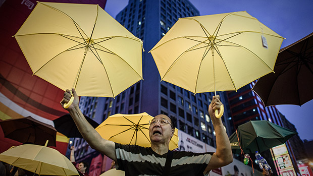 Manifestante pró-democracia segura guarda-chuvas durante um protesto em Hong Kong. O chefe do governo de Hong Kong, Leung Chun-ying, pediu desculpas nesta terça-feira (28/10) por causa das polêmicas declarações em que dizia que as eleições livres na ex-colônia britânica abririam espaço para um governo "para pobres".