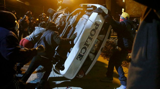 Nos Estados Unidos, manifestantes reviraram uma viatura policial em Ferguson, Missouri, na última segunda noite seguida de protestos após um júri inocentar o policial que matou um adolescente negro desarmado