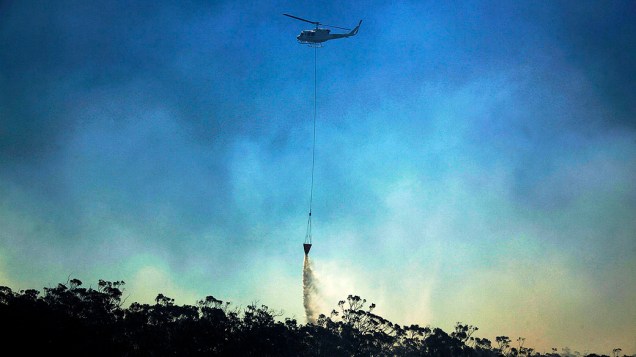 Helicóptero despeja água sobre um incêndio em Blue Mountains, a oeste de Sydney, na Austrália