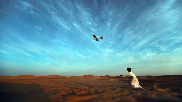 Menino corre atrás de avião durante festival de camelos nos Emirados Árabes