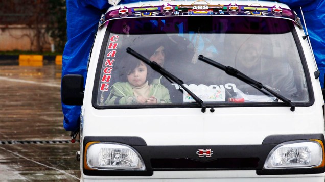 Menina síria em uma caminhonete enquanto atravessa a fronteira para a Turquia com sua família a partir do portão Cilvegozu