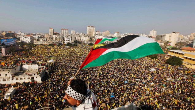 Menino carrega bandeira palestina durante comício que marca o 48º aniversário de fundação do movimento Fatah, na Cidade de Gaza 