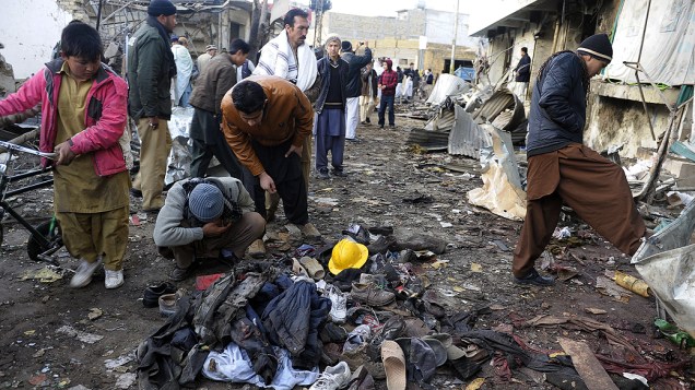 Pessoas observam o local onde ocorreu um bombardeio em Quetta, no Paquistão; Chega a 114 o número de mortos em explosões