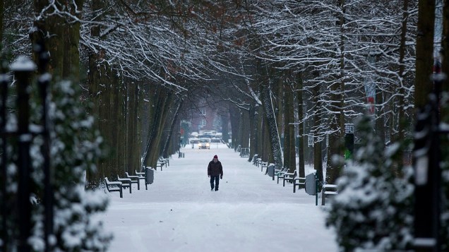 Homem caminha sobre a neve em parque de Wilrijk, na Bélgica