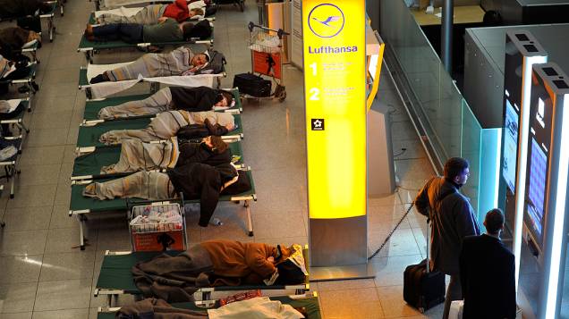 Muitos passageiros dormem no saguão do aeroporto em Munique e aguardam notícias sobre vôos cancelados por conta da neve