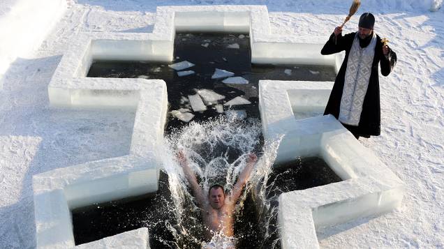 Ortodoxo mergulha em águas geladas para receber a benção de sacerdote na véspera do feriado da Epifania em Minsk, Belarus