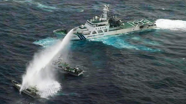 Navio da Guarda Costeira japonesa joga jato de água em barco de pesca, onde ativistas taiwaneses estvam a bordo no Mar da China Oriental