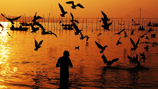 Indiano toma banho no rio Ganges durante manhã de quinta-feira (24) em praia de Mumbai, na Índia