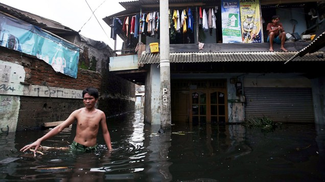 Vítima de enchente caminha em rua inundada em Jacarta, Indonésia