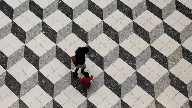 Menina caminha com sua mãe em um edifício de Tóquio, nesta quinta feira (24)