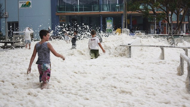 Crianças brincam com espuma do mar em Queensland, na Austrália. O estado foi atingido pelo ciclone tropical Oswald e sofre com as chuvas intensas
