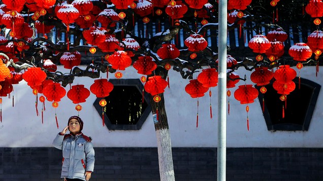 Criança observa decoração com lanternas durante visita ao parque Ditan em Pequim, na China