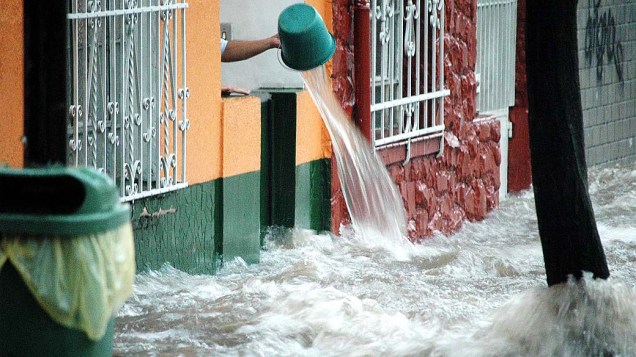 Alagamento obriga morador a retirar água de sua casa na rua Venâncio Aires, na região da Vila Pompéia em São Paulo (SP), nesta terça-feira (19)