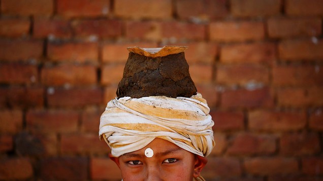 Menino carrega lâmpião sobre a cabeça retratando deus hindu Madhav Narayan, durante o festival Madhav Narayan, em Thecho, Nepal