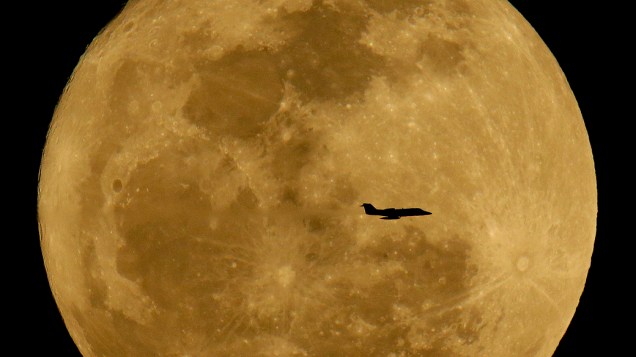 Silhueta de avião é vista em frente à lua no céu de Phoenix, nos EUA