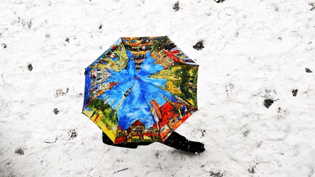 Uma pessoa usa guarda-chuva para caminhar em meio a tempestade de neve em Munique, na Alemanha