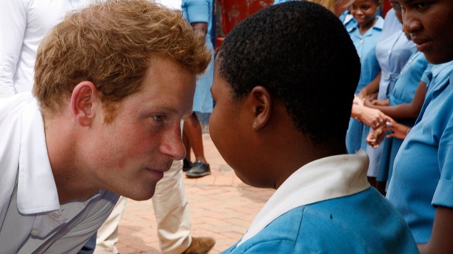 O príncipe britânico Harry conversa com criança de escola para deficientes visuais durante visita a Maseru, capital de Lesoto