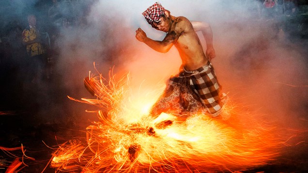 Homem chuta uma fogueira durante o ritual Perang Api, à frente do Nyepi, data do Ano Novo hindu em Bali, Indonésia, conhecido como dia do silêncio, quando hindus da ilha meditam e jejuam