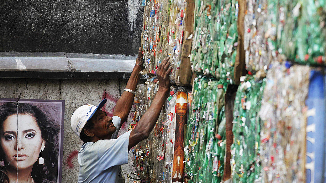 Roberto da Silva verifica os fardos de embalagens PET recolhidos por ele das águas poluídas do rio Tietê, em um centro de reciclagem em Santana do Parnaíba, São Paulo
