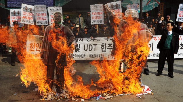Ativistas sul-coreanos queimam dois retratos de antigos líderes norte-coreanos, Kim Il-Sung e Kim Jong-Il, durante manifestação contra a Coreia do Norte