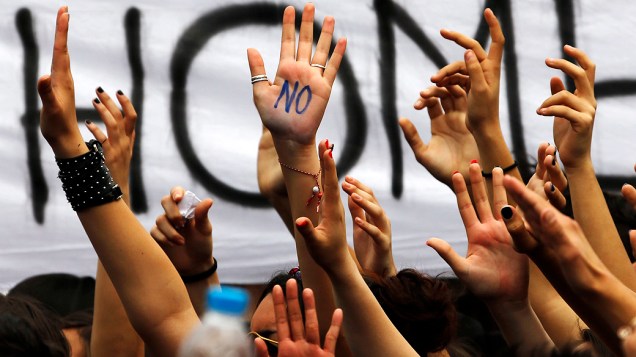 Estudante universitário mostra a palavra Não na palma de sua mão durante protesto que reuniu centenas em frente ao parlamento do Chipre em Nicósia