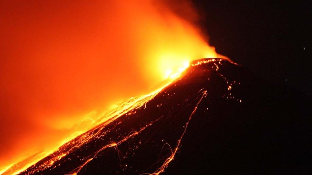 Vulcão expele lava no topo do Monte Karangetang, visto da vila de Bebali, em Sitaro (Indonésia)