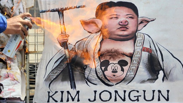 Ativista sul-coreano queima caricatura do líder norte-coreano Kim Jong-Un, durante um comício anti-Coreia do Norte, em Seul