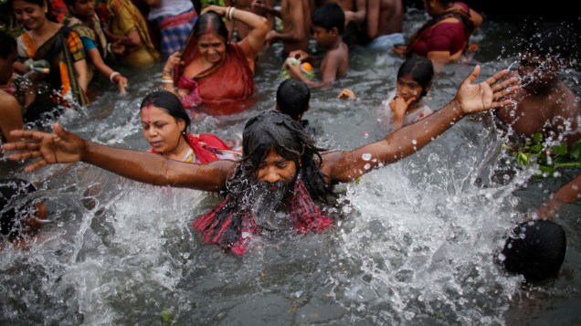Devoto toma banho, para lavar seus pecados, durante o festival Astami Snan, em Bangladesh