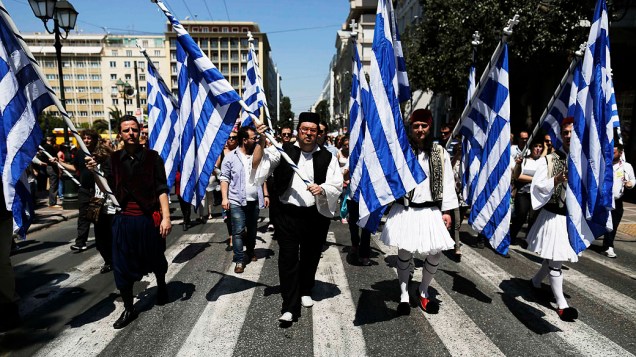 Trabalhadores municipais se vestem com trajes tradicionais durante protesto contra planos de demissões de milhares de trabalhadores do setor público, como parte de programa de reformas de austeridade, em Atenas, na Grécia