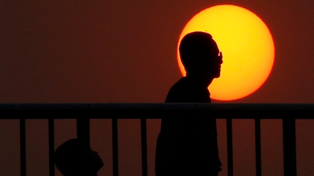 Pessoas são vistas durante pôr do sol em Pequim, na China