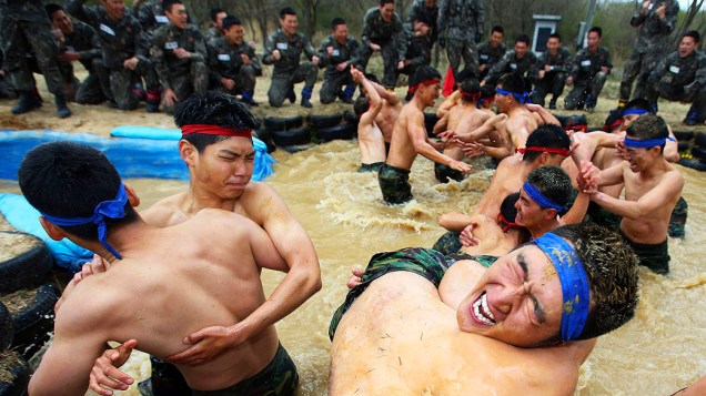 Membros das forças especiais sul-coreanas lutam em uma piscina de lama durante um exercício militar em Yeongcheon, a sudeste de Seul