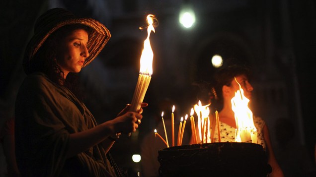 Em Jerusalém, mulher acende velas nas celebrações da Páscoa ortodoxa