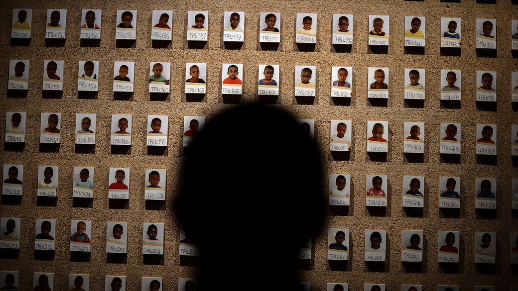 Um visitante olha para uma parede de fotografias tiradas em 1994 mostrando crianças separadas de suas famílias em Ruanda, na nova exposição permanente da Cruz Vermelha Internacional em Genebra.