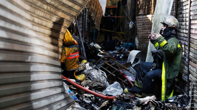 Bombeiro atende local onde vinte lojas foram destruídas após um incêndio a partir de um curto-circuito na seção de moda no famoso Mercado Chatuchak, em Bangcoc, Tailândia